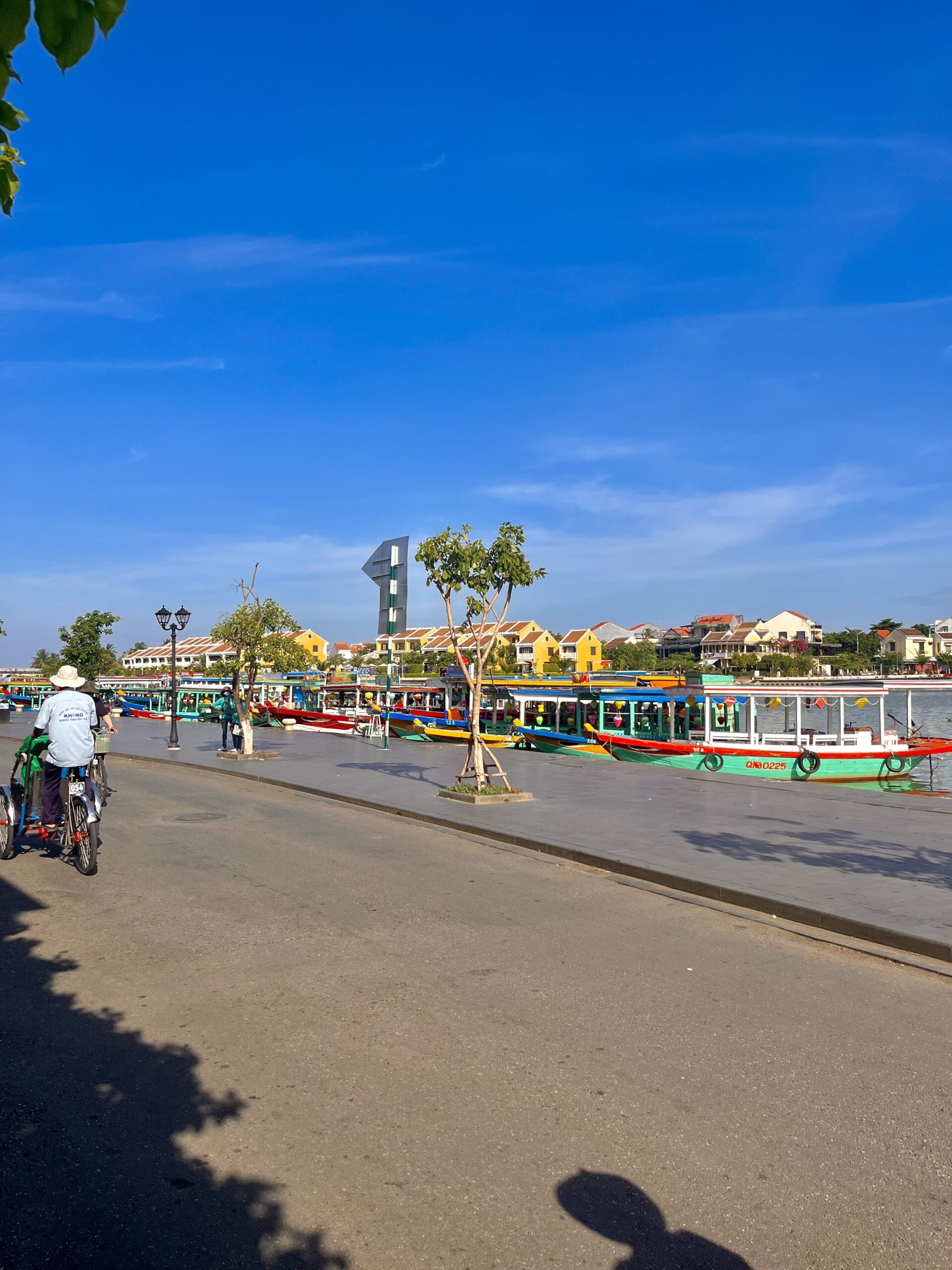 "Scenic view of boats and the bustling market in Hoi An, Vietnam, showcasing the vibrant local life and colourful atmosphere of this UNESCO World Heritage town."