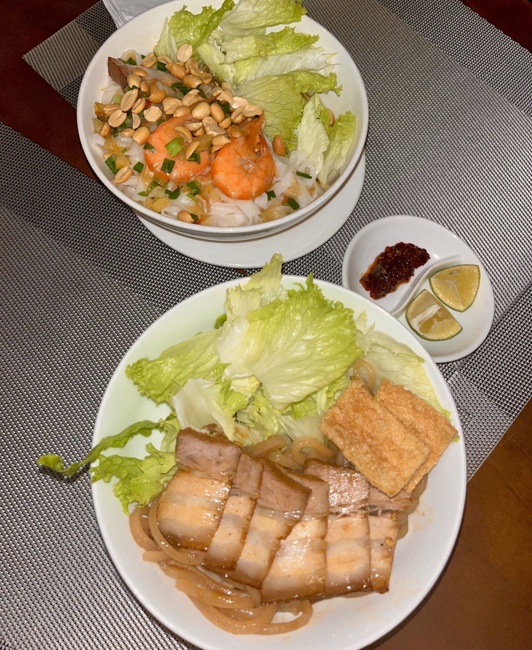 "Delicious bowl of Cao Lau, a traditional Hoi An noodle dish with thick rice noodles, tender pork, fresh herbs, and crispy croutons, served in a rich broth."