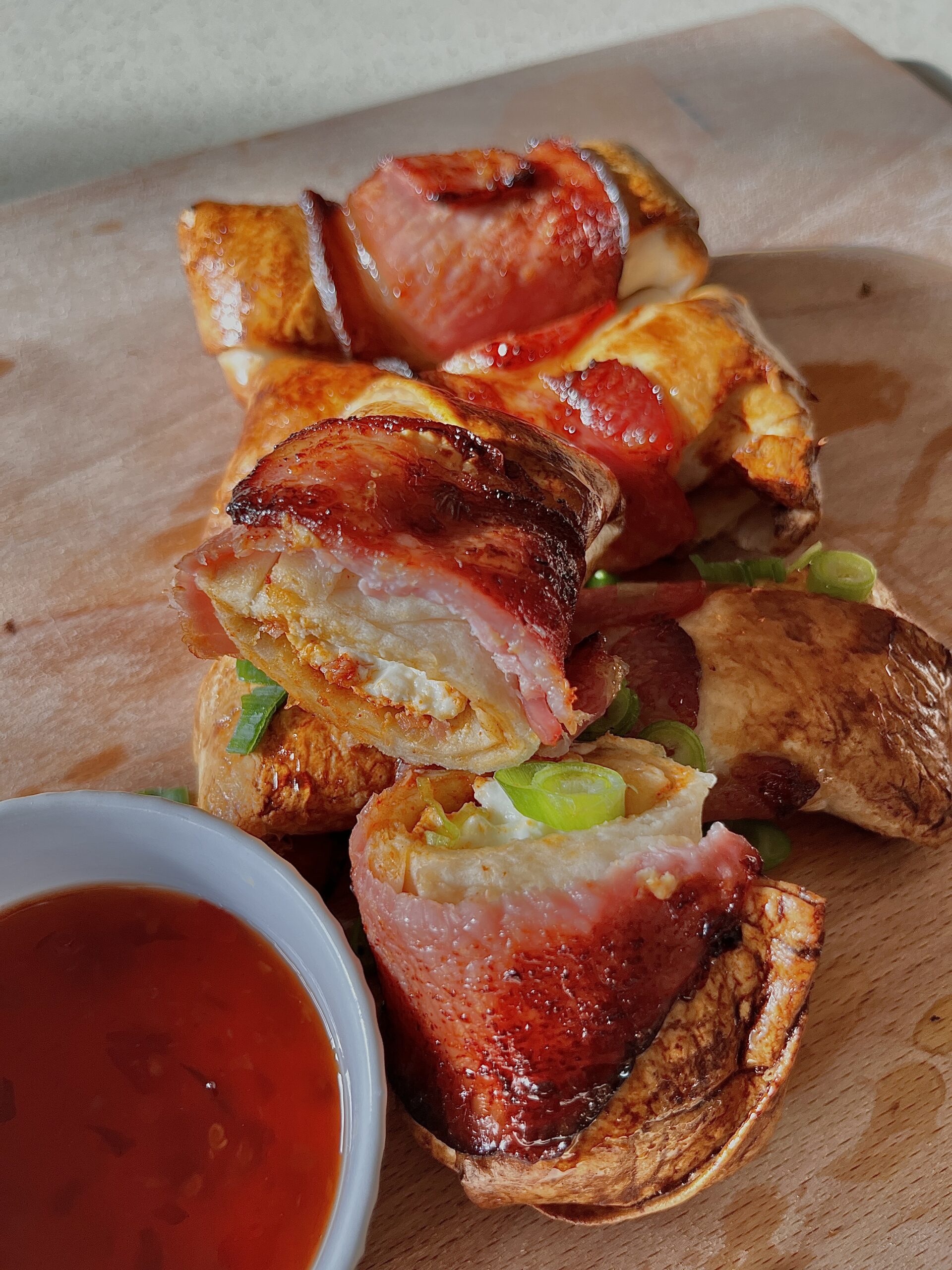 Crispy bacon-wrapped feta bites drizzled with golden honey, served on a white plate. This easy air fryer appetiser combines salty feta, smoky bacon, and sweet honey, making it the perfect party snack or Mediterranean-inspired starter.