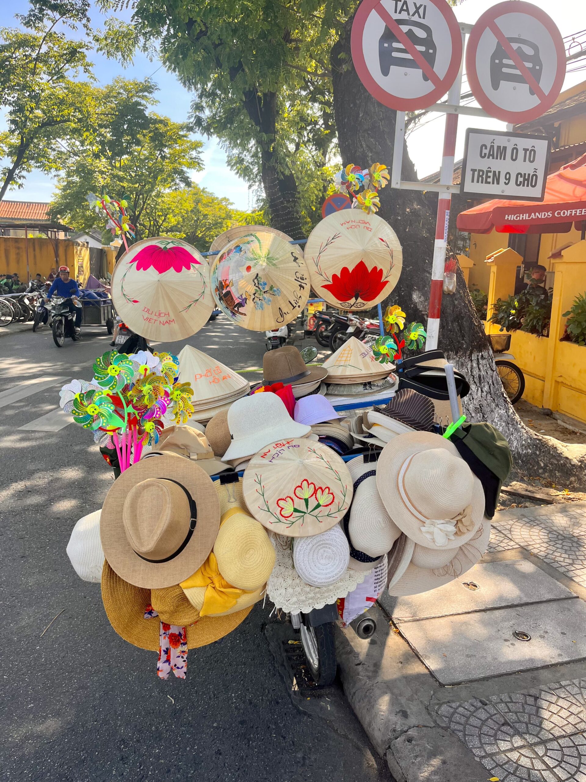 "Conical hat trader in Hoi An, Vietnam, showcasing traditional Vietnamese craftsmanship and cultural heritage in the bustling streets of the UNESCO World Heritage town."