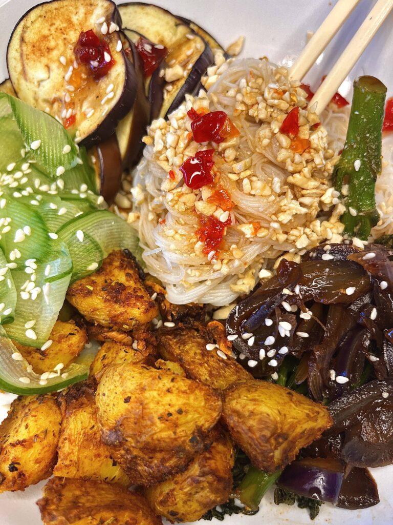 Vegetarian bún chả bowl with roasted garlic potatoes, fried aubergine, cucumber, vermicelli noodles, sweet soy tenderstem broccoli, and a jalapeño chilli soy sauce.